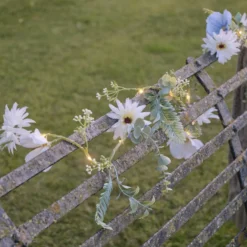 Beleuchteter Kranz und Girlande mit blauen und weißen Blüten