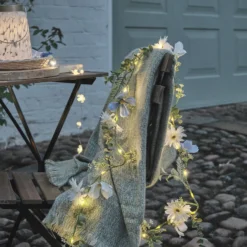 Beleuchteter Kranz und Girlande mit blauen und weißen Blüten